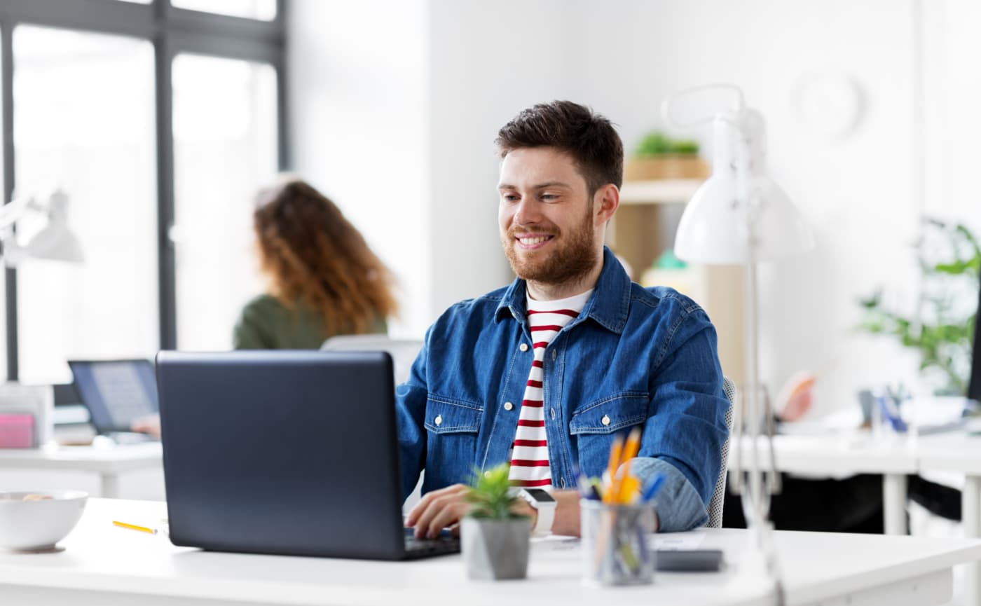 Medewerker aan het werk op een laptop in een licht kantoor